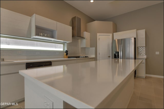 kitchen featuring wall chimney range hood, white cabinetry, black cooktop, a kitchen island, and stainless steel fridge with ice dispenser