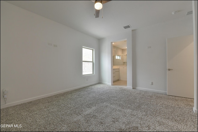 unfurnished bedroom featuring ceiling fan, light colored carpet, and ensuite bathroom