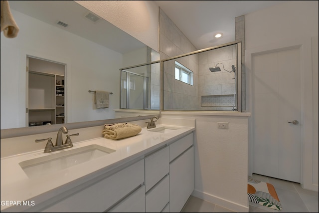 bathroom featuring tiled shower, vanity, and tile patterned floors