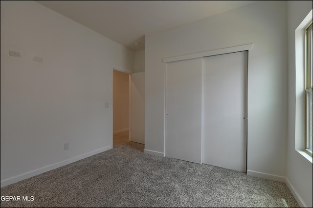 unfurnished bedroom with carpet flooring, multiple windows, and a closet