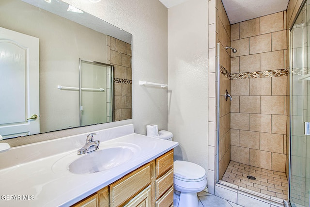 bathroom with an enclosed shower, vanity, toilet, and tile floors