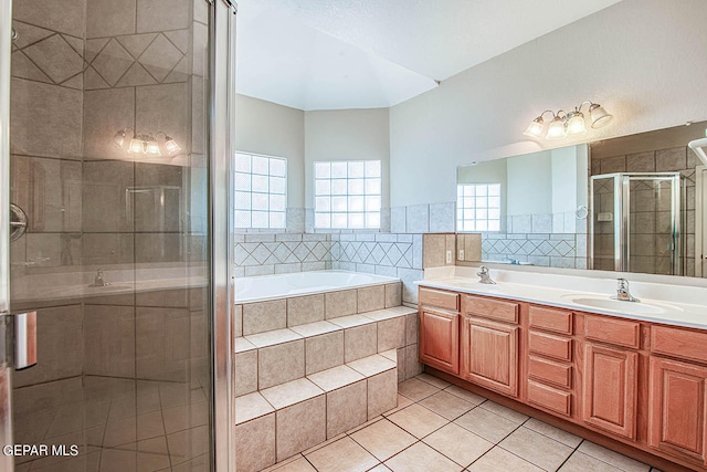 bathroom with double vanity, tile flooring, and separate shower and tub