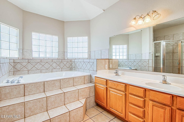 bathroom with a healthy amount of sunlight, double sink, shower with separate bathtub, and large vanity