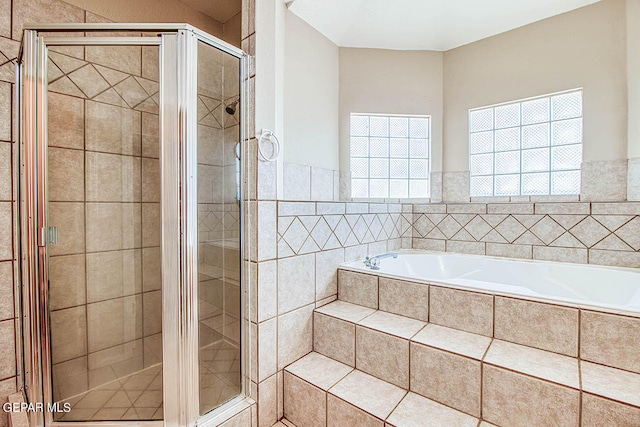 bathroom featuring independent shower and bath