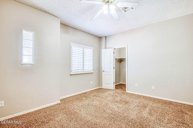 unfurnished bedroom featuring ceiling fan, a closet, a textured ceiling, and carpet flooring