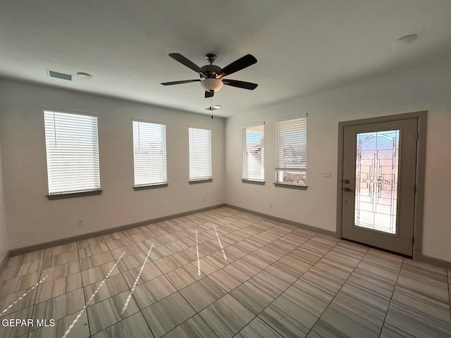 tiled spare room with ceiling fan