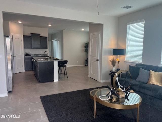 living room with recessed lighting, visible vents, baseboards, and light tile patterned floors