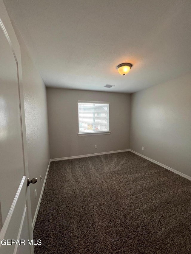 unfurnished room featuring carpet, visible vents, and baseboards