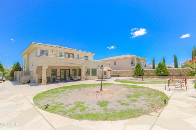 back of property featuring an outdoor living space, a patio, a balcony, and ceiling fan