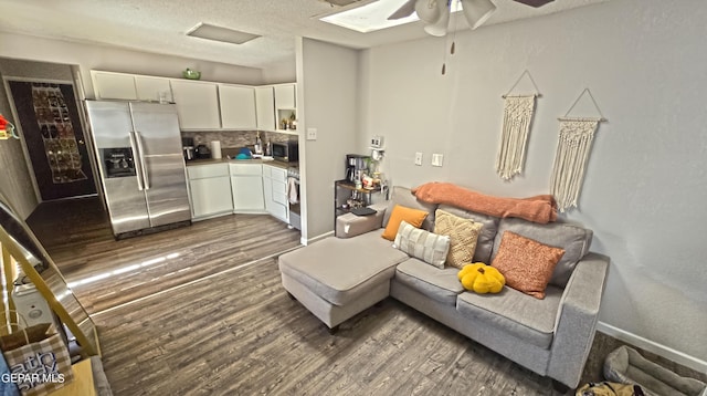 living room featuring a textured ceiling, dark hardwood / wood-style floors, and ceiling fan