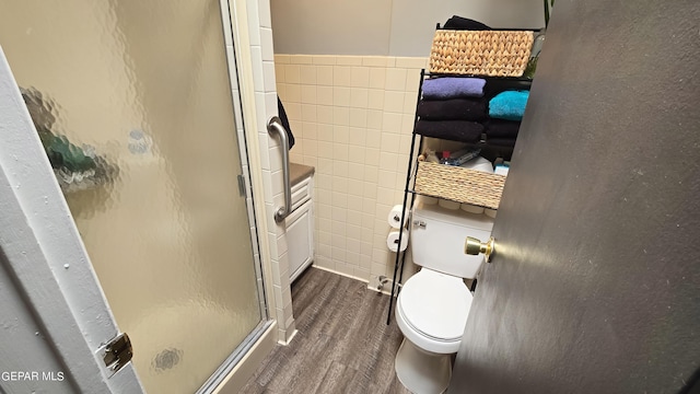 bathroom featuring hardwood / wood-style flooring, toilet, and an enclosed shower