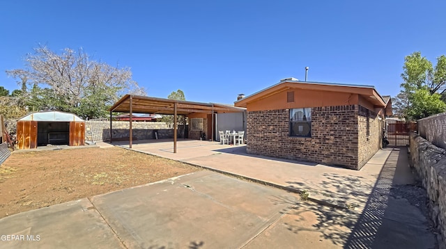 rear view of house with a patio area and a storage shed