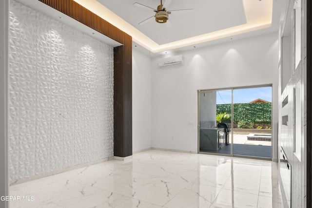 spare room featuring ceiling fan, a raised ceiling, and an AC wall unit