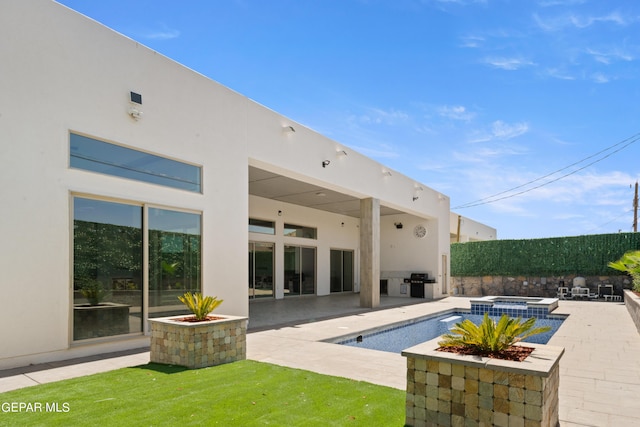 view of pool with a patio, an in ground hot tub, and grilling area