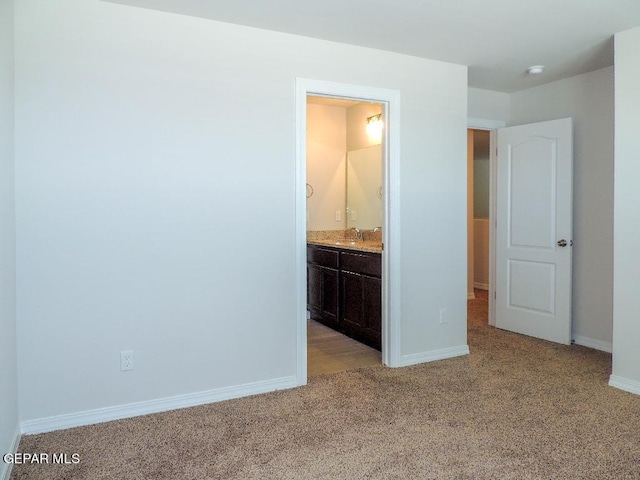 unfurnished bedroom with light carpet, connected bathroom, and sink