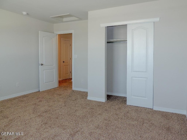 unfurnished bedroom featuring light carpet and a closet