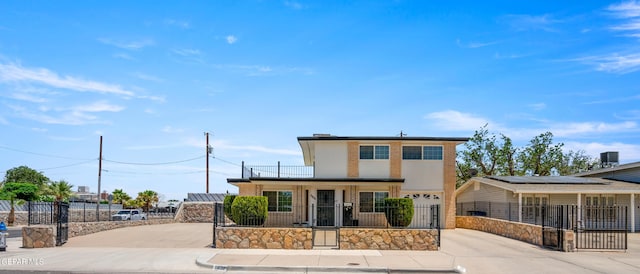 view of front facade featuring a fenced front yard, roof mounted solar panels, driveway, and a gate