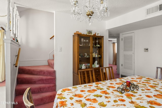 bedroom with a chandelier, visible vents, and a textured ceiling