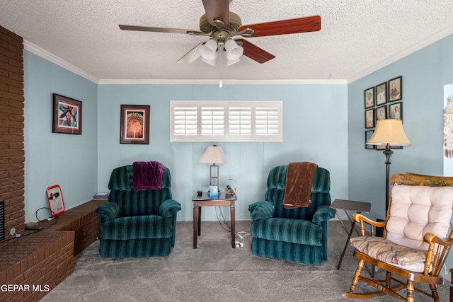 living area with ornamental molding, carpet, ceiling fan, and a textured ceiling