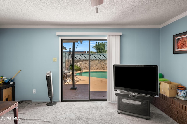 living area with a textured ceiling, ornamental molding, and carpet