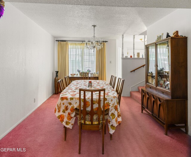 carpeted dining area featuring an inviting chandelier and a textured ceiling