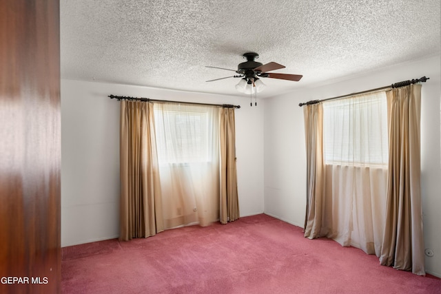 spare room with carpet, a textured ceiling, and a ceiling fan