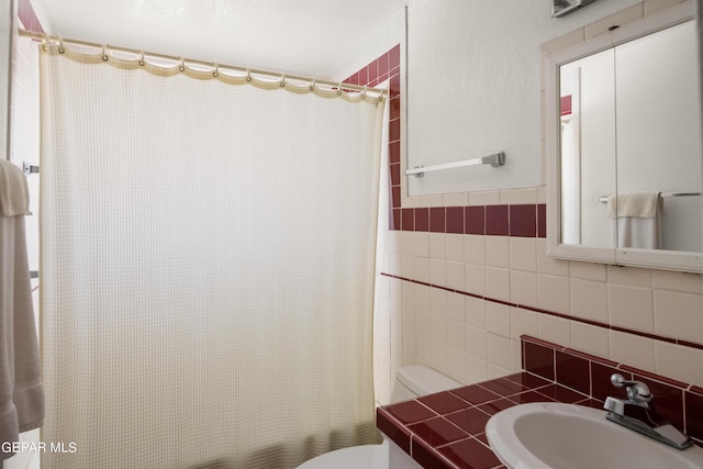 bathroom with toilet, tile walls, and vanity