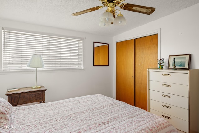 bedroom with ceiling fan, a textured ceiling, and a closet