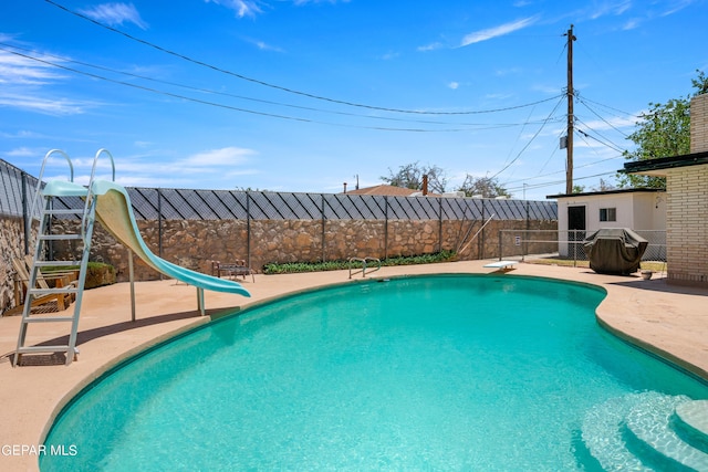 view of pool with a patio area, a fenced backyard, a fenced in pool, and a water slide