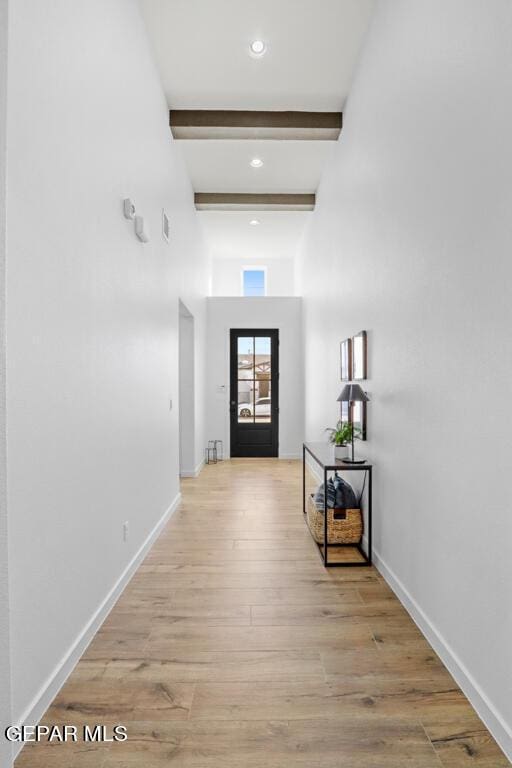 hall featuring beam ceiling and light wood-type flooring