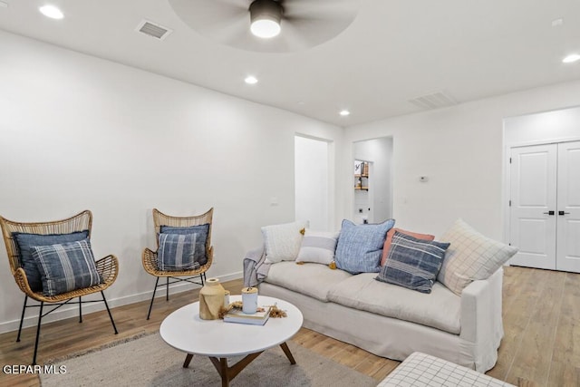 living room with ceiling fan and light hardwood / wood-style flooring