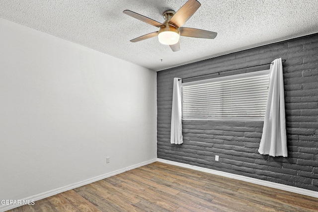 spare room featuring dark hardwood / wood-style floors, ceiling fan, and a textured ceiling