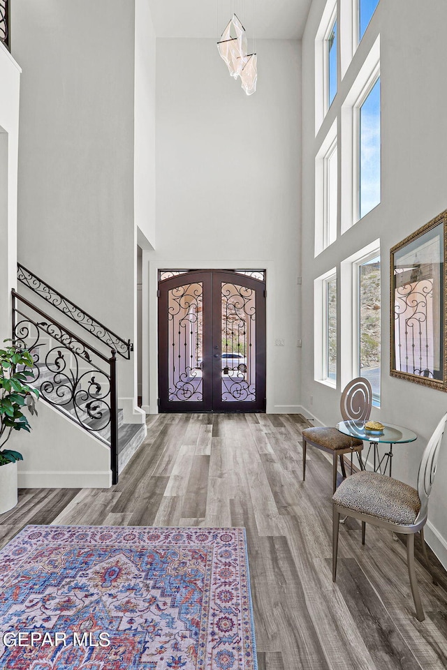 entryway featuring hardwood / wood-style flooring, a high ceiling, and french doors