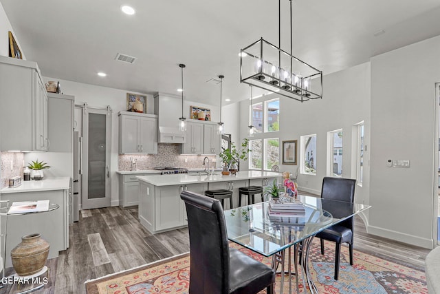 dining room featuring a barn door, sink, a high ceiling, and hardwood / wood-style flooring