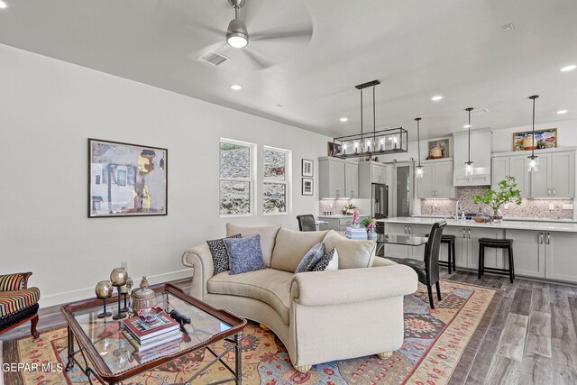 living room featuring dark hardwood / wood-style floors, ceiling fan, and sink