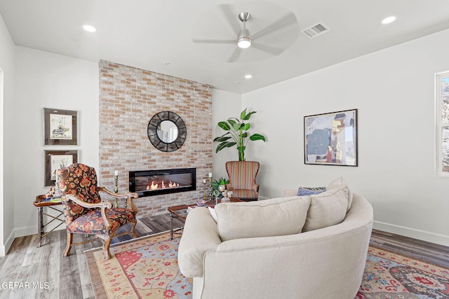 living room featuring a fireplace, ceiling fan, and hardwood / wood-style floors