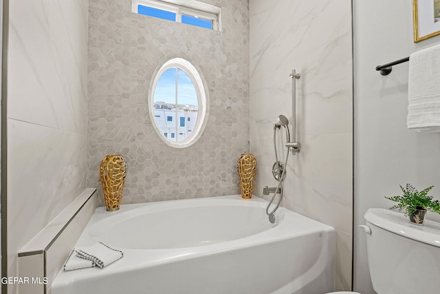 bathroom featuring a bath and toilet