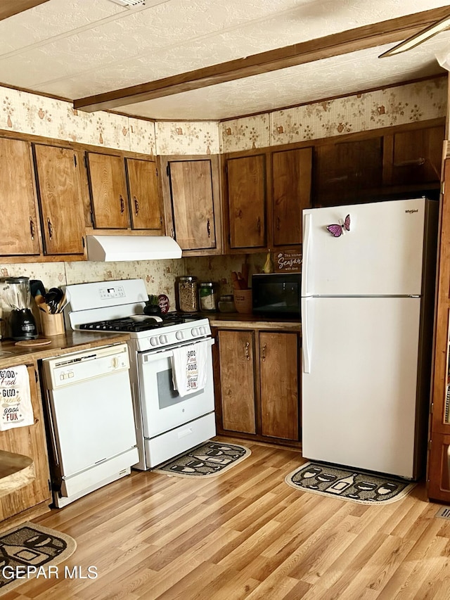 kitchen featuring beamed ceiling, white appliances, a textured ceiling, and light hardwood / wood-style flooring