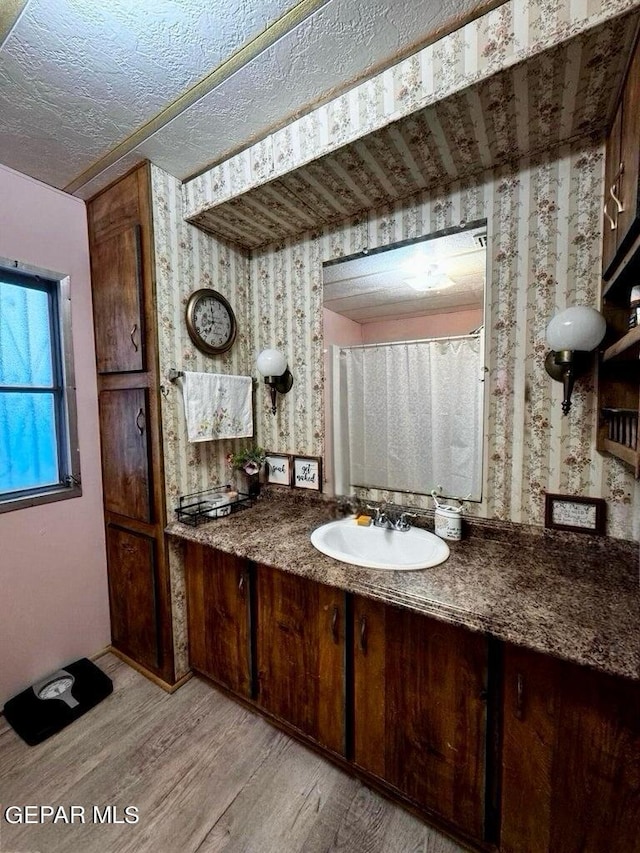 bathroom with vanity, a textured ceiling, and hardwood / wood-style flooring