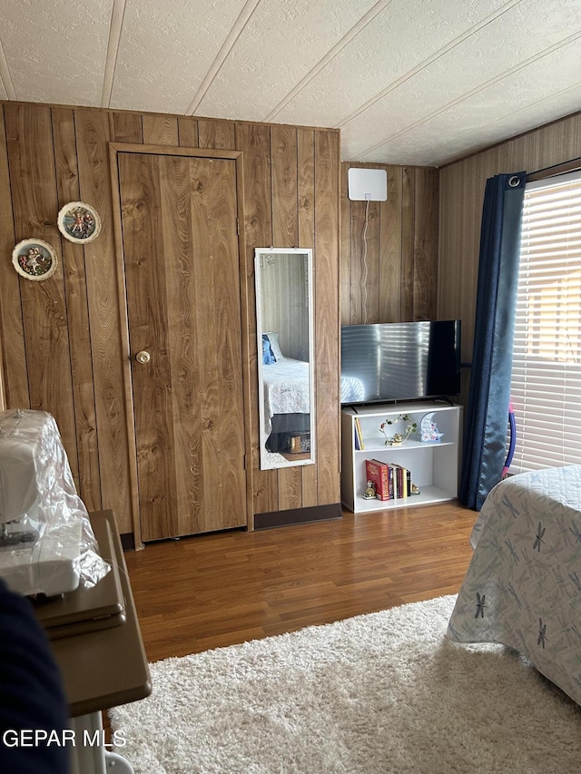 bedroom featuring wood walls and wood-type flooring