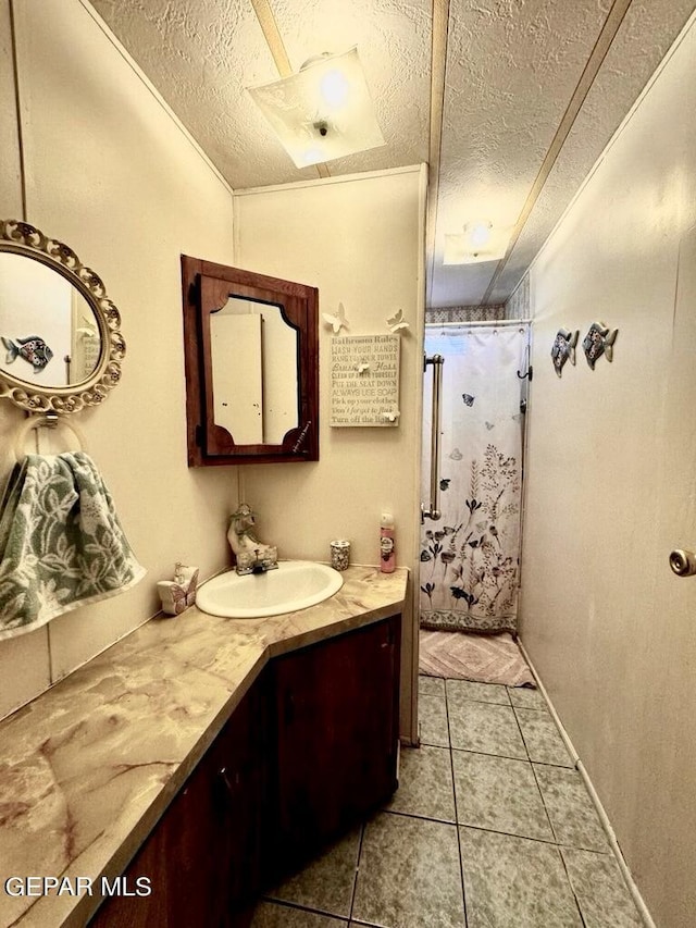 bathroom with tile patterned floors, vanity, a shower with curtain, and a textured ceiling