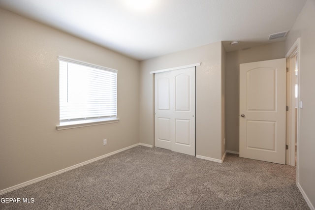 unfurnished bedroom with carpet and a closet