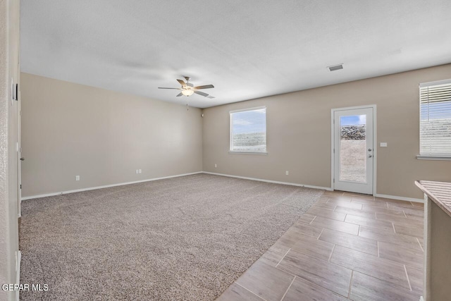 empty room with ceiling fan and light colored carpet