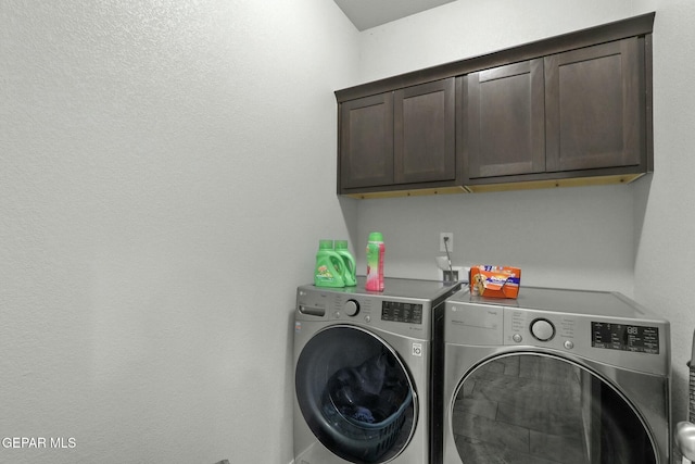 washroom featuring separate washer and dryer and cabinets