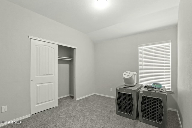 unfurnished bedroom with light colored carpet, a closet, and lofted ceiling