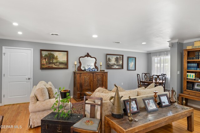 living room with recessed lighting, visible vents, light wood-style floors, ornamental molding, and baseboards