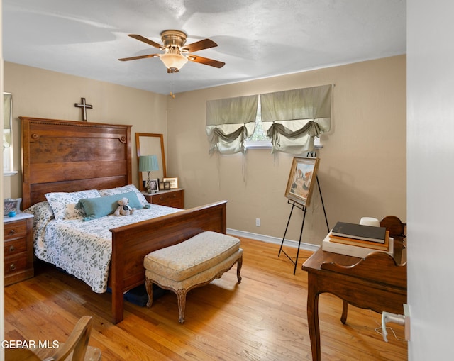 bedroom with light wood finished floors, ceiling fan, and baseboards