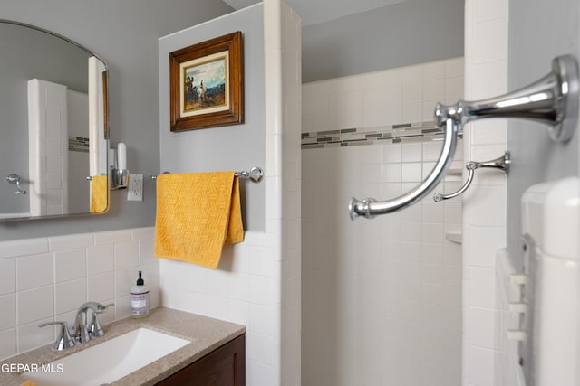 bathroom with vanity and tile walls