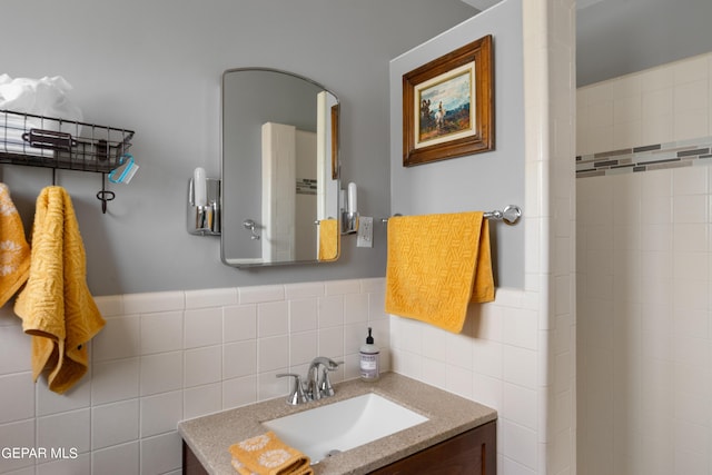 full bath featuring wainscoting, tile walls, and vanity