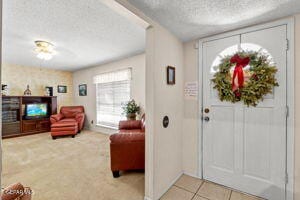 entryway with tile patterned floors and a textured ceiling